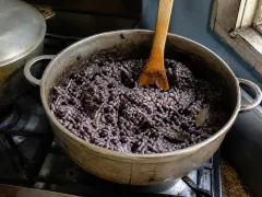 A pot of moros y cristianos — long-grain rice stained dark by black bean liquor, the beans still whole and distributed through the grains.