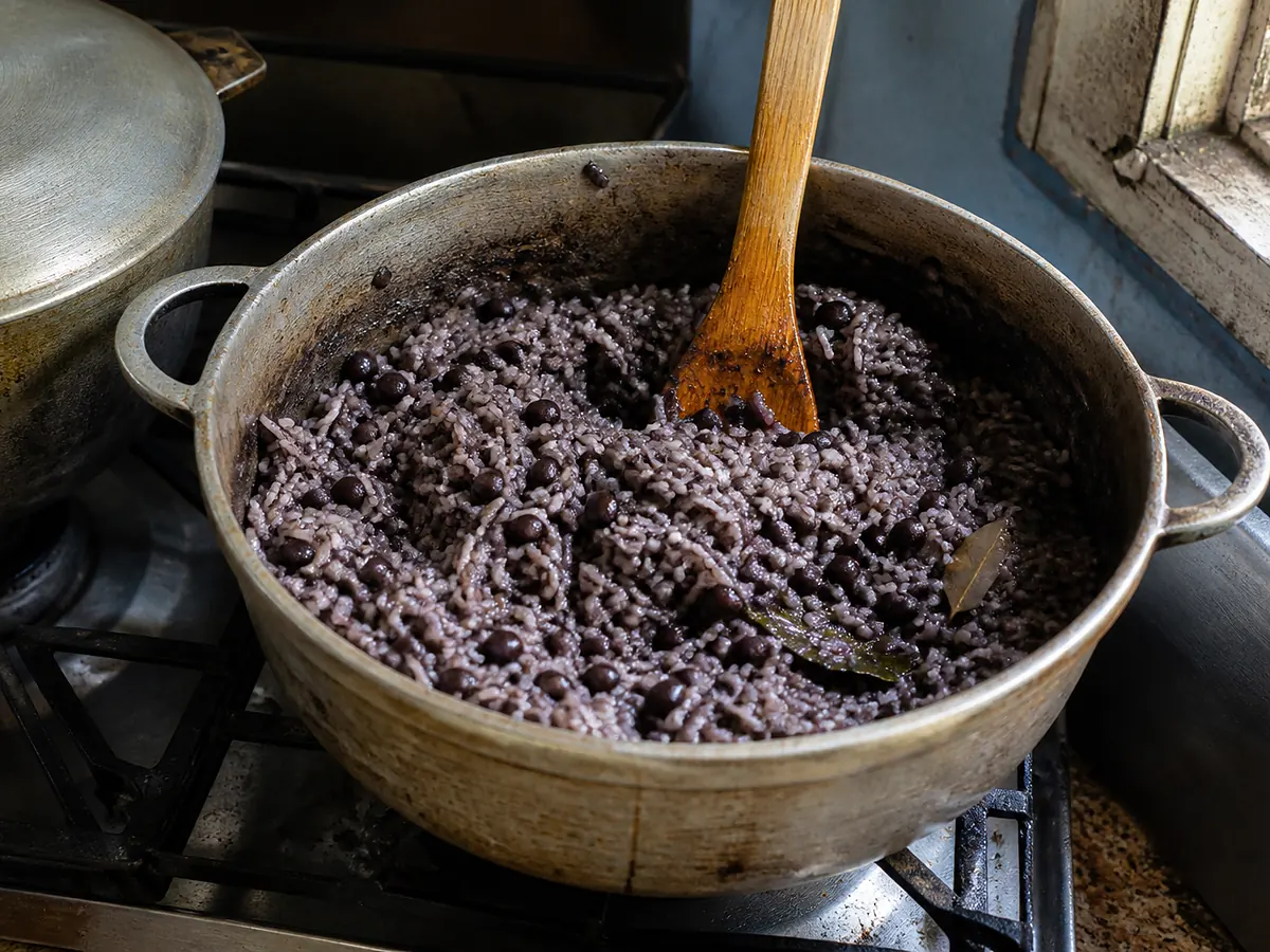 A pot of moros y cristianos — long-grain rice stained dark by black bean liquor, the beans still whole and distributed through the grains.