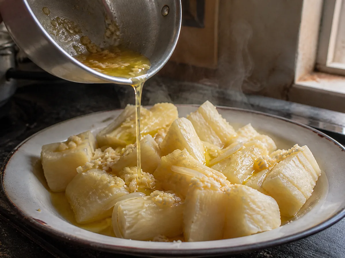 Glossy chunks of boiled yuca under a garlic-and-onion mojo, the sliced garlic gold and the onion wilted into the cracks.