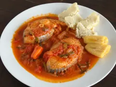 Fish steaks in a glossy red tomato and lime court-bouillon with onion and herbs, served with cassava and pieces of couac.